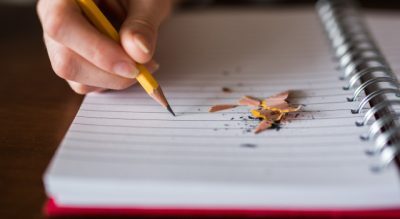 Personholdingpencilonnotebook