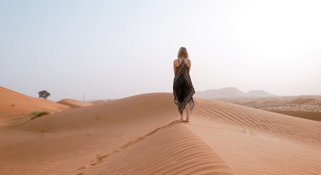 Womanwalkingonsandindesertduringdaytime